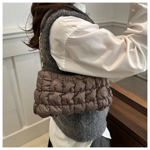 Detail of coffee quilted cloud bag with gold chain strap and textured puff fabric