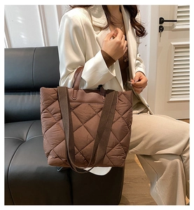 Détail d'un grand sac cabas matelassé marron avec surpiqûres losanges et anses