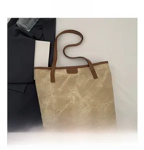 Detail view of large tote bag with marble pattern canvas and brown leather trim