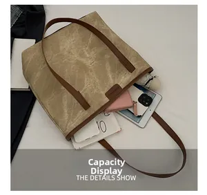 Detail view of large tote bag capacity showing tablet, phone, books, and umbrella inside