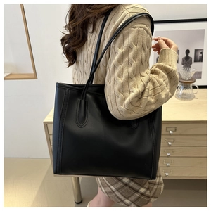 Detail of minimalist black PU leather tote bag showing fine stitching and large capacity