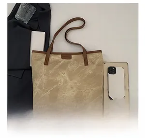 Detailed view of the large tote bag with office essentials and a stylish tablet on the side