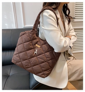 Sac fourre-tout matelassé marron avec pendentif cerf doré porté à l'épaule