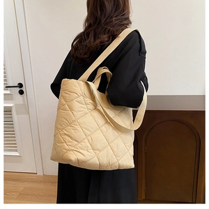 Détail du grand sac cabas matelassé beige avec surpiqûres en losanges et bandoulière