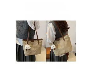 Detail of marble pattern tote bag with brown straps and white plush pendant