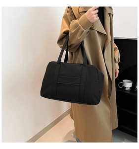 Close-up of large black nylon tote bag with front zipper pocket for daily commuting