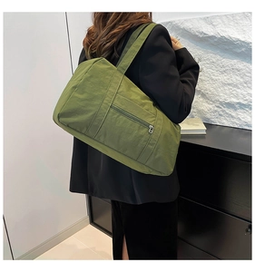 Olive green high-capacity tote bag shown from side view on a model for travel and commute