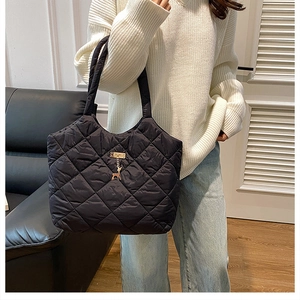 Détail du grand sac cabas noir matelassé avec pendentif cerf doré et texture nylon