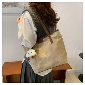 Grand sac fourre-tout kaki avec lanières en cuir marron et charm nuage blanc sur un modèle