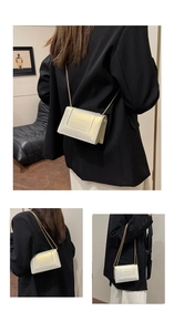 Close-up of a gold metallic crossbody bag with textured leather and gold chain strap