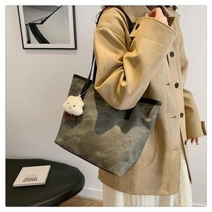 Détail du grand sac cabas en toile grise avec un pendentif en peluche nuage blanc