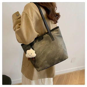 Détail d'un grand cabas vintage olive avec fines anses noires et charm nuage blanc