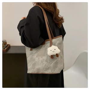 Détail du cabas gris à motif marbré avec anses marron et breloque nuage blanc