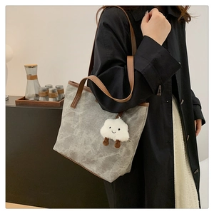 Close-up of grey marble texture tote bag with brown leather straps and cloud charm