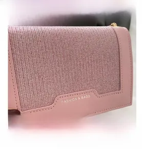 Détail des textures de cuir rose et de tissu pailleté avec une bandoulière chaîne dorée