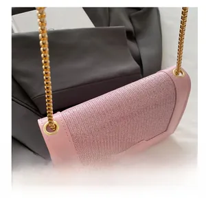 Détail du sac bandoulière rose en tissu et cuir avec chaîne serpent dorée élégante