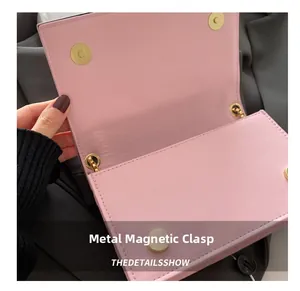 Gros plan sur le fermoir magnétique et la texture du cuir rose de ce sac bandoulière