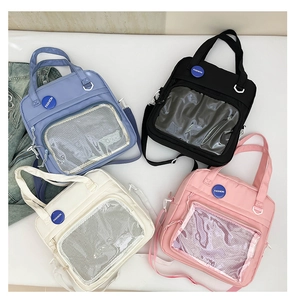 Vista plana de bolsos de nailon coloridos con bolsillos transparentes en azul, negro y rosa