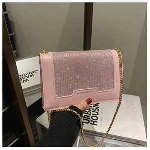 Vue détaillée du sac rose orné de strass brillants avec bandoulière chaîne dorée
