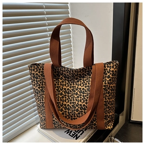 Vue détaillée du sac cabas en toile à imprimé léopard avec des anses marron sur une table