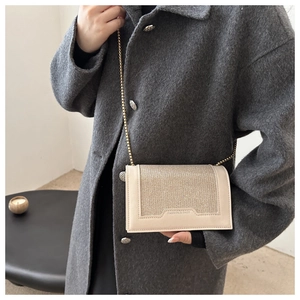 Détail du sac à paillettes beige avec chaîne dorée et logo Fashion & Bags embossé