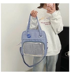 Bolso de hombro en nylon azul con un gran bolsillo de malla transparente y detalle de placa