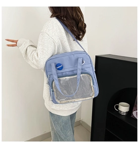 Detalle del bolso tote de nailon azul claro con bolsillo de malla y placa de moda