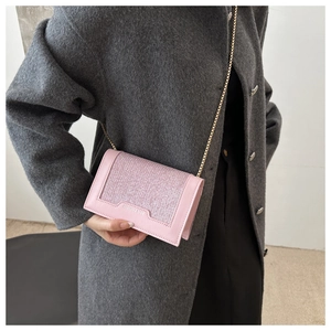 Détail du sac à bandoulière rose à paillettes avec chaîne dorée sur mannequin