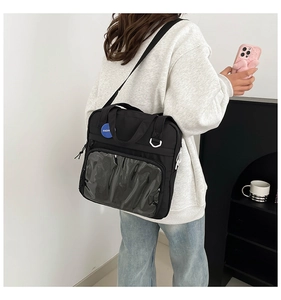 Detalle de bolso negro de nailon con ventana de PVC transparente y correa ajustable