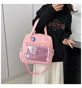 Vista detallada del bolso informal rosa con bolsillo frontal transparente y chapa azul