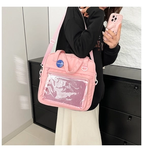 Detalle del bolso rosa con un bolsillo frontal transparente para pines y peluches