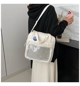 Detalle de bolso de lona blanco con bolsillo de malla transparente y correa ajustable