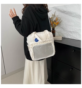 Detalle de bolso de lona blanca con bolsillo de malla y placa de moda para uso diario