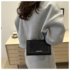 Modèle portant le sac à chaîne à paillettes noires avec détail FASHION & BAGS