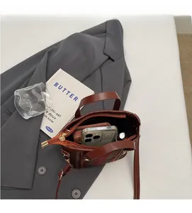 Internal view showing storage capacity of red plaid mini bucket bag with leather handles