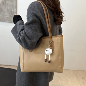 Large khaki PU leather tote bag for women with a cute white plush monster charm