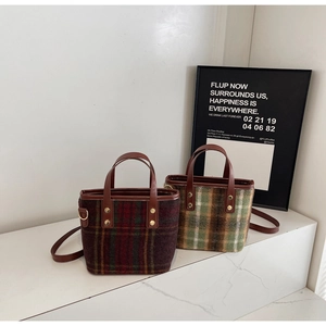 Detail of wool plaid tote bags with leather handles and metallic rivet reinforcements