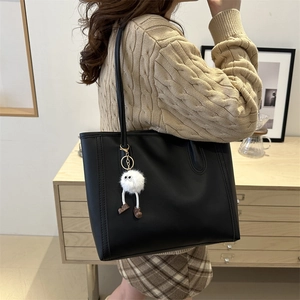 Large black PU leather tote bag for women with a cute white plush charm on the shoulder strap