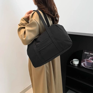 Minimalist black nylon tote bag for women with wide shoulder straps and zipper pocket