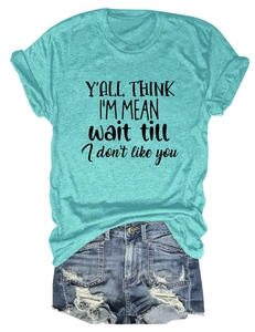 Detail of mint green T-shirt with black slogan print and distressed denim shorts