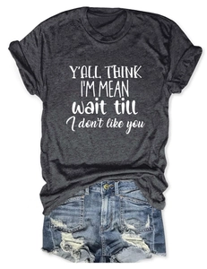 Close-up of white graphic text on a dark grey crew neck t-shirt with denim shorts