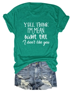 Flat lay of a dark green short sleeve T-shirt with white text and ripped denim shorts