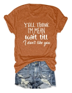 Burnt orange crew neck T-shirt with slogan paired with distressed denim shorts