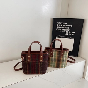 Plaid wool bucket bags with brown leather handles and rivets in red and yellow patterns