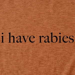 Détail du tissu en maille rouge rouille avec le slogan i have rabies imprimé en noir