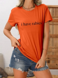 Détail du t-shirt orange à col rond avec texte I Have Rabies et short en jean