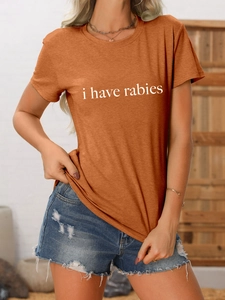Détail du t-shirt caramel avec texte i have rabies et short en jean bleu délavé à trous