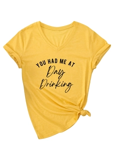 Detail of a mustard yellow V-neck T-shirt featuring a knot-front hem and graphic print