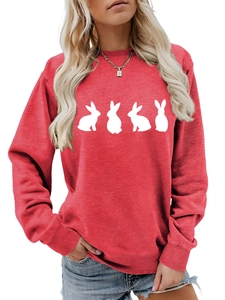 Detail of red crewneck sweatshirt featuring white rabbit silhouettes and cotton fabric texture