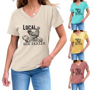 Détail de l'imprimé Local Egg Dealer sur t-shirts col V en beige, bleu, jaune et rose